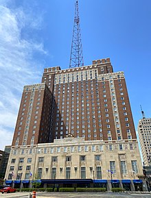 A 1920s Art Deco hotel building with a large transmitter tower on top
