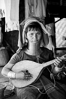 Mulher Karen tocando um instrumento de madeira caseiro na província de Mae Hong Son, Tailândia.