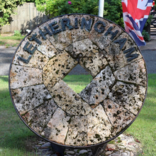 Letheringham village sign, a millstone from the old watermill Letheringham village sign, a millstone from the old watermill.webp