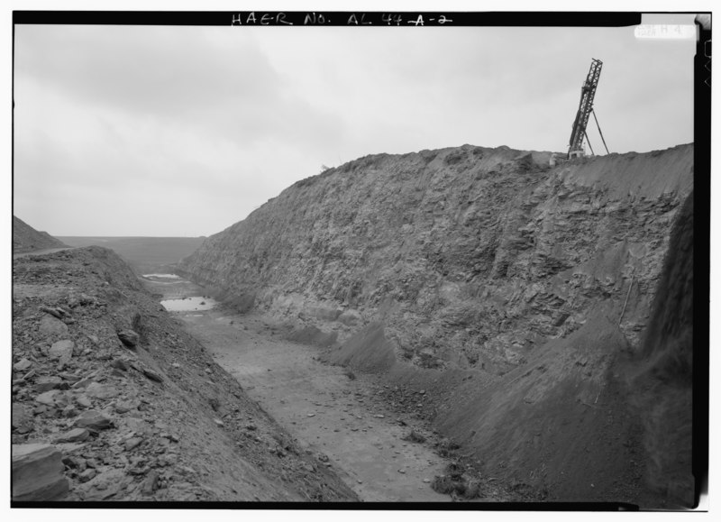 File:OVERVIEW, LOOKING SOUTHWEST, TO 8750 PIT WITH DRILL SETTING AN EXPLOSIVE CHARGE TO REMOVE OVERBURDEN AND ACCESS COAL SEAMS LOCATED 200 FEET BELOW FOR STRIPPING. - Drummond Coal HAER ALA,64-TOWN,3A-2.tif