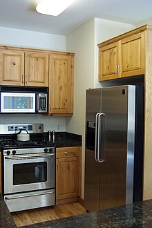 A kitchen with a range of types of domestic technology, including an oven, a microwave oven and a refrigerator