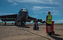 A member of No. 13 Squadron standing by a USAF Boeing B-52 Stratofortress with a bioenvironmental security kit in 2018