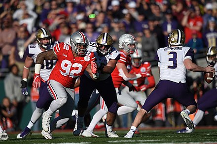 Jake Browning (right) scrambles to escape Ohio State's defensive pressure during the first half of the game