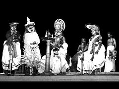 Guru Mani Madhava Chakyar and his troupe performing Thoranayudham (part of Bhasa's play Abhiseka Nataka based on the epic Ramayana) Koodiyattam (1962, Chennai). It was the first ever Koodiyattam performance outside Kerala. Thoranayudham- Madras1.jpg