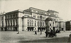 Un edificio de piedra muy grande de tres pisos de altura de estilo de principios del siglo XVIII, con muchas ventanas estrechas en las paredes