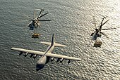 US Navy 030130-M-0000X-001 Two U.S. Marine Corps CH-53E Super Stallion helicopters assigned to Marine Heavy Helicopter Squadron-772 (HMM-772) receive fuel from a KC-130 Hercules.jpg