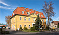 Ehemalige Poststation mit Einfriedung in offener Bebauung, heute Schule