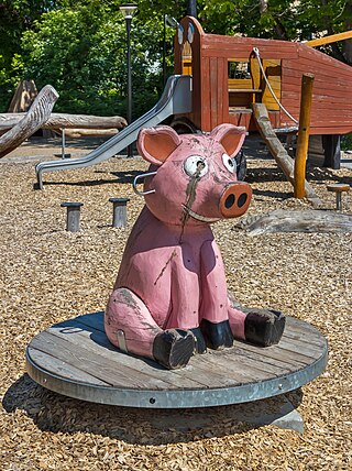 Wooden pig merry-go-round at a playground in Brastad