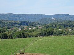 Paysage de Magny-Danigon avec le clocher du temple, vu depuis Andornay. En arrière-plan, la chapelle Notre-Dame du Haut de Ronchamp sur la colline de Bourlémont.