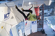 Climber wearing fruit boots while performing a figure-four move in the 2016 Ice Climbing World Cup 2016 UIAA Ice Climbing World Tour Cheongsong - 88.jpg