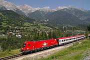 14. KW Sonderlackierung zur Fußball-Europameisterschaft 2008 (EM-Taurus Schweiz) der ÖBB mit dem EC 662 auf der Arlbergbahn bei der Durchfahrt in Pians, Bundesland Tirol. Im Hintergrund von links nach rechts: Gatschkopf (2945 m), Blankahorn (2822 m), Wannenkopf (2821 m) und Rauher Kopf (2811 m). Aufgenommen am 17. Juli 2007.