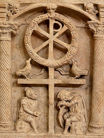 O Cristograma com uma coroa de flores simbolizando a vitória da Ressurreição.