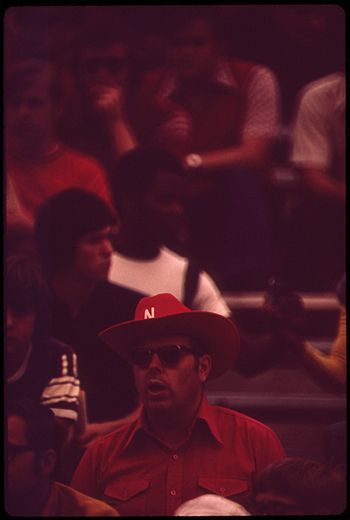 A fan attends a football game at Memorial Stadium in 1973