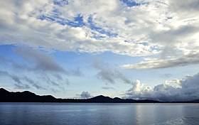 Foto Talaga Tondano tempo pagi. Depe aer so biru, sama lei depe langi so biru deng ada banya awan tapi langi masi dapa talia jo. Trus ada lei gunung-gunung talia di depe tepi.