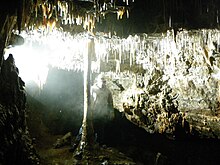 A potholer beside the column in Crackpot Cave