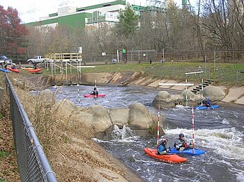 Dickerson Whitewater Course starting point. Power plant in background. Plastic kayaks enter the course by sliding down the concrete channel wall. More delicate fiberglass or composite slalom boats can be carried down the steps.