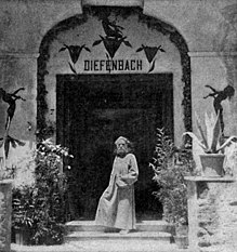 Der ca. 60-jährige Diefenbach steht, mit einer Reformkutte bekleidet, vor dem Eingang seines Hauses auf Capri