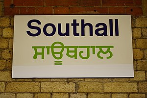 Bilingual English and Punjabi (Gurmukhi) sign at Southall railway station in the London, UK