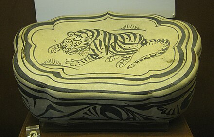Oreiller de céramique Jin cizhou à motif de tigre sur un nuage. Peint au brun d'oxyde de fer sur engobe blanche. Musée du mausolée du roi Nanyue. Guangzhou.