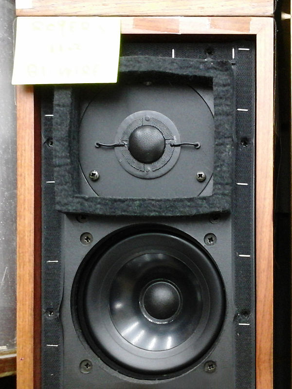A small "bookshelf speaker", an LS3/5A, with its protective grille cover removed.