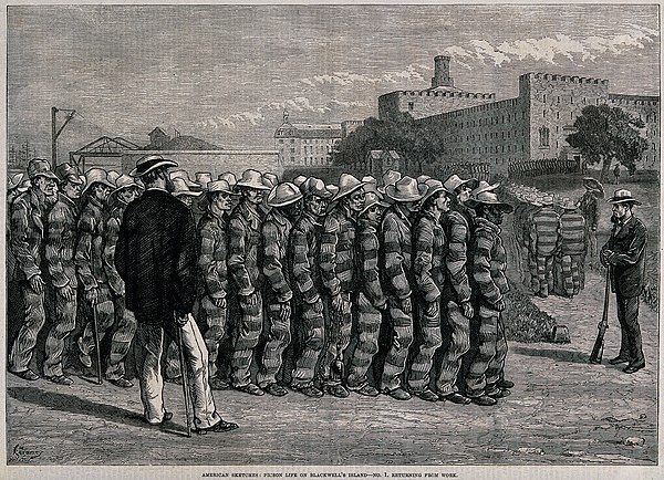 Lines of men in prisoner's uniforms marching towards a building