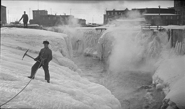 Men with pickaxes chipping away at the ice of the Chaudière Falls, 1918
