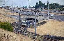 Photograph of the MAX Green Line's tunnel under I-205 with a southbound train entering it