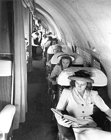 Passengers on Pan Am Strato-Clipper in the Raymond Loewy-designed interior. Seats on the left could be folded into sleeper bunks Passengers on a Pan Am Boeing 307.jpg