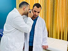 A doctor performs an otoscopy examination. Performing an Otoscopic exam.jpg