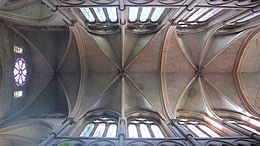 Vue couleur de la voûte de la nef d’une cathédrale en contre-plongée, aux travées divisées en six parties par trois ogives.