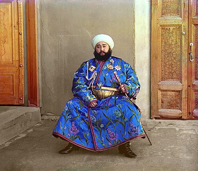 Alim Khan's bemedaled robe conveys a social message about his wealth, status, and power