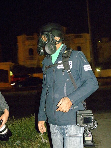 Reuters photographer Hamad I Mohamed wearing a gas mask while covering a protest