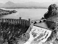 El lado aguas abajo de la presa Roosevelt, con el lago Roosevelt lleno, y el aliviadero en el terraplén izquierdo de la presa se está utilizando para liberar agua.