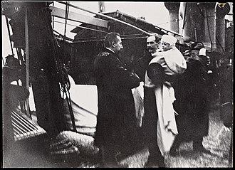 Photograph depicting the real arrival of King Haakon VII in 1905 Statsminister Christian Michelsen mottar kong Haakon 7 og kronprins Olav ombord det norske marinefartoyet "Heimdal", 25. november 1905 (8588724605).jpg