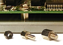 Two sizes of metal standoffs and one plastic standoff. The background depicts a standoff in use, holding a circuit board above a metal case. Three types of standoffs.jpg