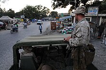 US Navy 100207-N-2735T-055 Sgt. Tom Maloney from the 24th Marine Expeditionary Unit (24th MEU) looks out at a crowded street during a reconnaissance patrol.jpg