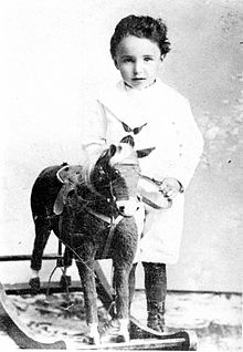monochrome foto van een kind met een hobbelpaard