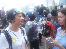 Mask and ribbon-equipped democracy protester, Civic Party committee member and former legislator Audrey Eu interviewed on Lung Wui Rd near Tim Mei Ave, 10.53 am 28 September 2014 1053 28 Sep 2014 Audrey Eu.jpg