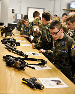 A Civil Air Patrol cadet reads the nomenclature of a security forces squadron M4 carbine at the 182nd Airlift Wing. An Illinois Wing Civil Air Patrol cadet reads the nomenclature of a security forces squadron M4 carbine.jpg