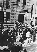 Photo d'une foule rassemblée à la porte d'un grand bâtiment.