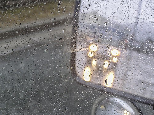 City bus driving in the rain.