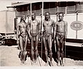 Four young Masai tribesmen, carrying spears, standing beside Wellcome V0048592.jpg