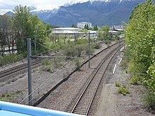 Vestige de la gare de Grenoble-Olympique représenté par le quai central et le quai Nord le long des deux voies de la ligne de Grenoble à Montmélian (vue en direction de l'ouest).