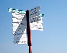 A bilingual sign. The languages are English and Anishinaabe. Lakehead University Which-Way Sign.jpg