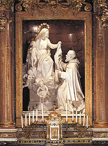Statue of the Virgin Mary giving the Scapular to Simon Stock (19th-century) by Alfonso Balzico located in the church of Santa Maria della Vittoria, Rome Mariascapular.jpg