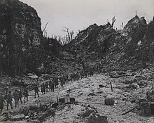 Photo en noir et blanc de soldats au milieu d'un paysage dévasté