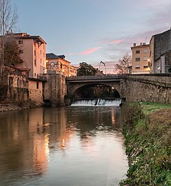 Photo prise à l'aube en aval du pont. La minoterie et le théâtre de Mont-de-Marsan sont visibles sur la gauche et la cale de l'Abreuvoir sur la droite, donnant accès au port de Mont-de-Marsan, actif jusqu'en 1903.