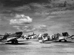 Trois avions monoplan au sol.  Les hélices avant des trois avions ont été retirées.