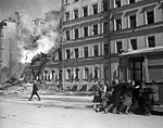 Inwoner duwen een tram weg nadat er een Duitse luchtaanval geweest is. 1 januari 1942.