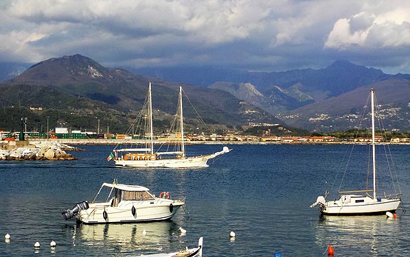 Sail boat leaving Marina di Carrara harbor, Italy